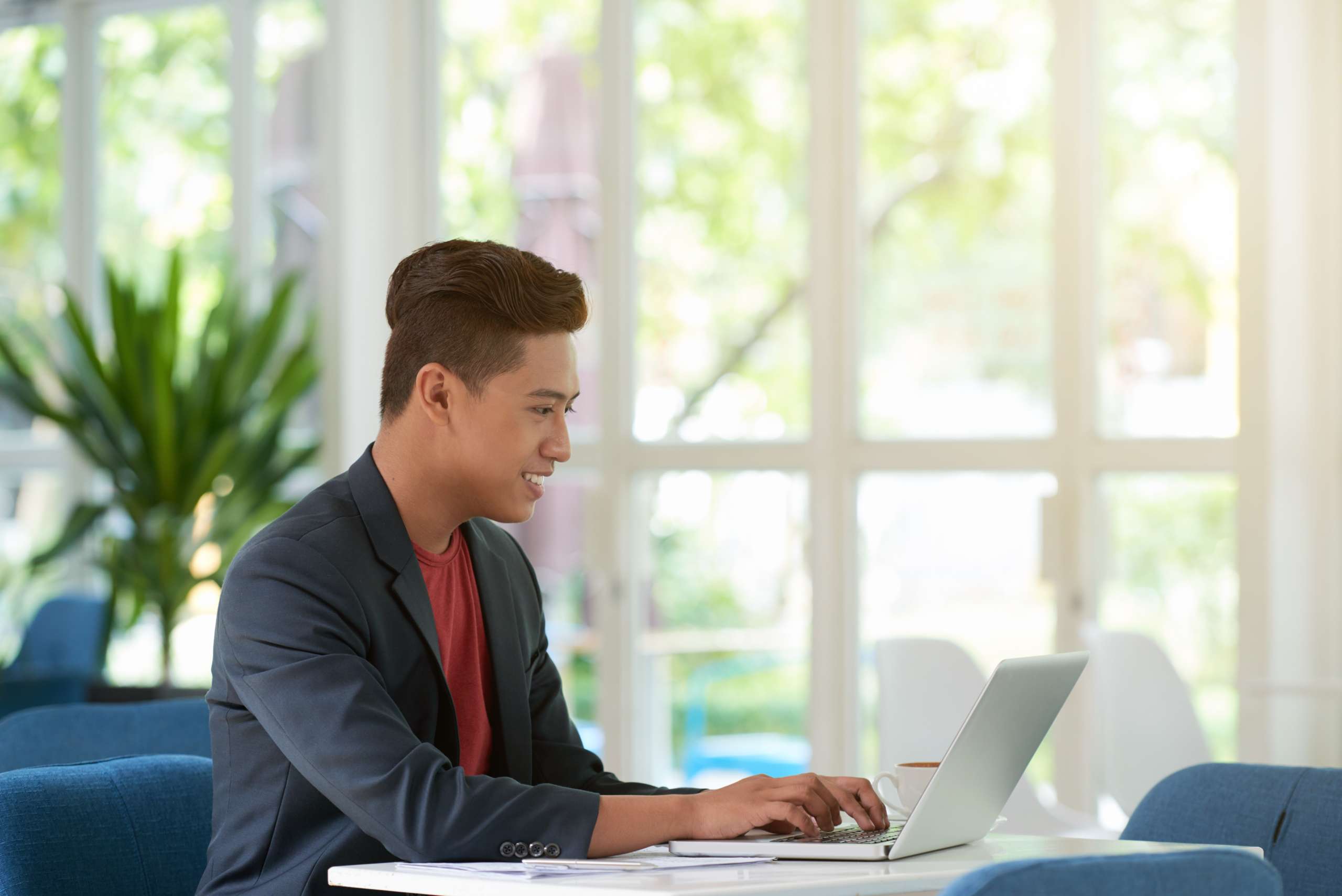 side-view-man-busy-typing-laptop-keyboard-with-smile